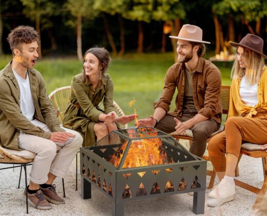 two women and two men sitting round a fire pit to keep warm, laughing and joking