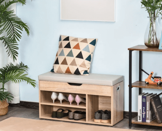 oak wood effect sit-on shoe storage cabinet, containing pairs of shoes and a diamond pattern cushion laying on the top, against a pale blue wall