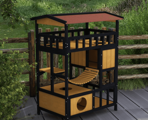 a black metal framed outdoor cat house with wooden rooms, a bridge and a top platform, standing on grey wood decking